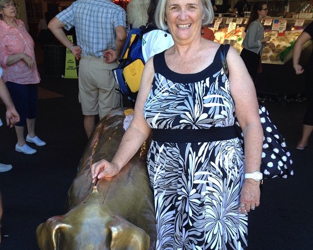 The Golden Pig, an icon of downtown Seattle, stand to receive donations. Peggy is feeding him.